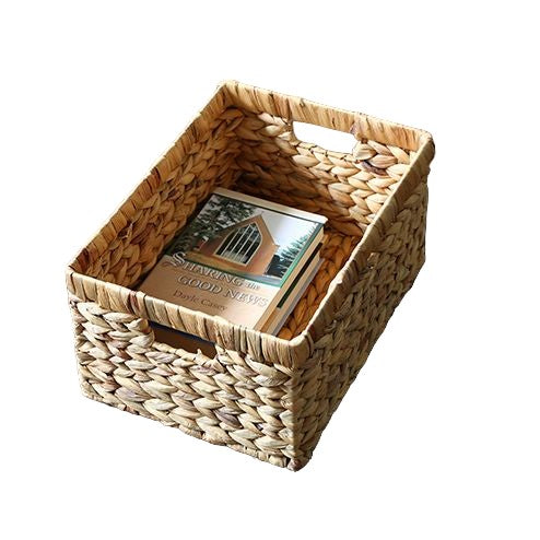 Rectangular woven wicker basket with handles, containing a book, ideal for storage and organization.